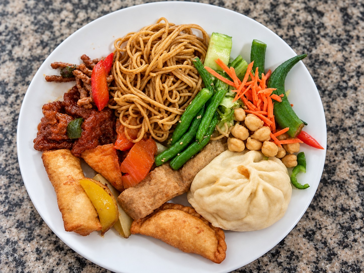 Prato vegetariano com macarrão, legumes, grão-de-bico, rolinho primavera, pastel e pão no vapor